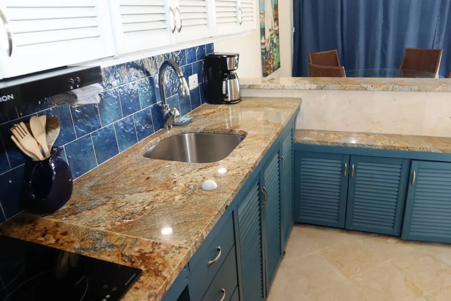Guest room kitchenette with blue cabinets, sink, cooktop, and coffee maker at Point Pleasant Resort.