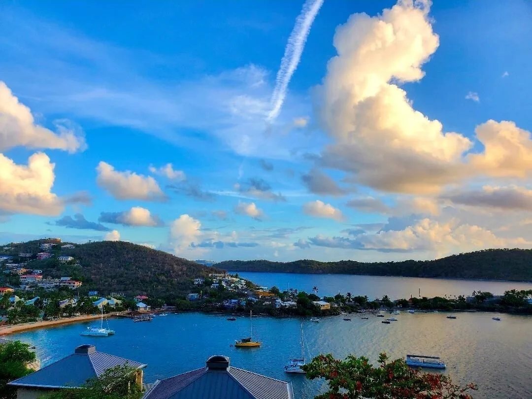 Harbor and hillside view under dramatic clouds at Point Pleasant Resort.