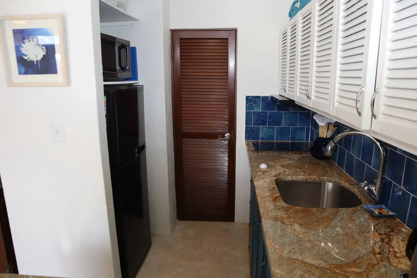 Narrow kitchenette with sink, refrigerator and microwave at Point Pleasant Resort.