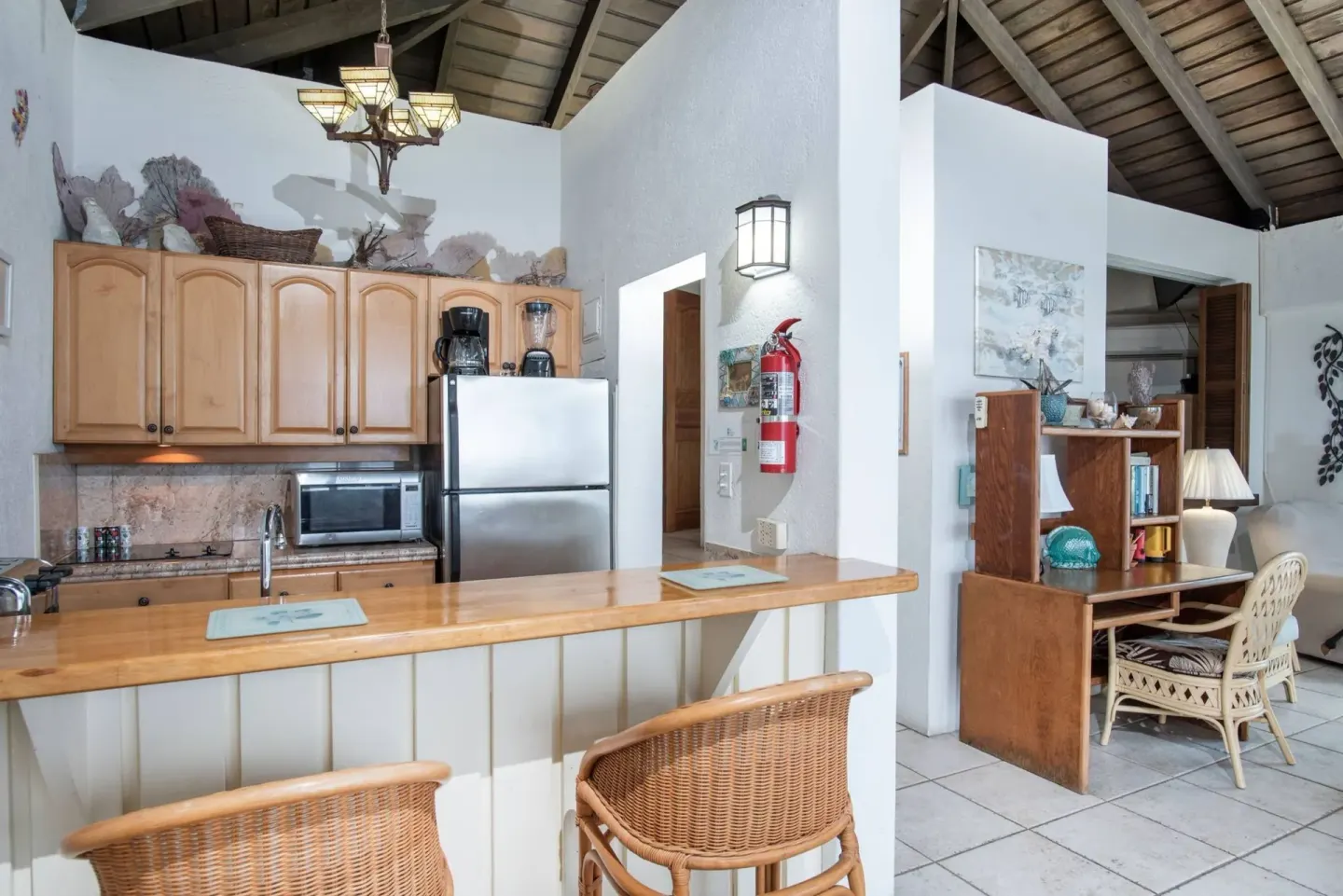 Open kitchenette and desk area with wicker chairs at Point Pleasant Resort.