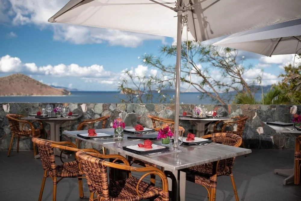Open-air restaurant terrace with set tables and sea view at Point Pleasant Resort.