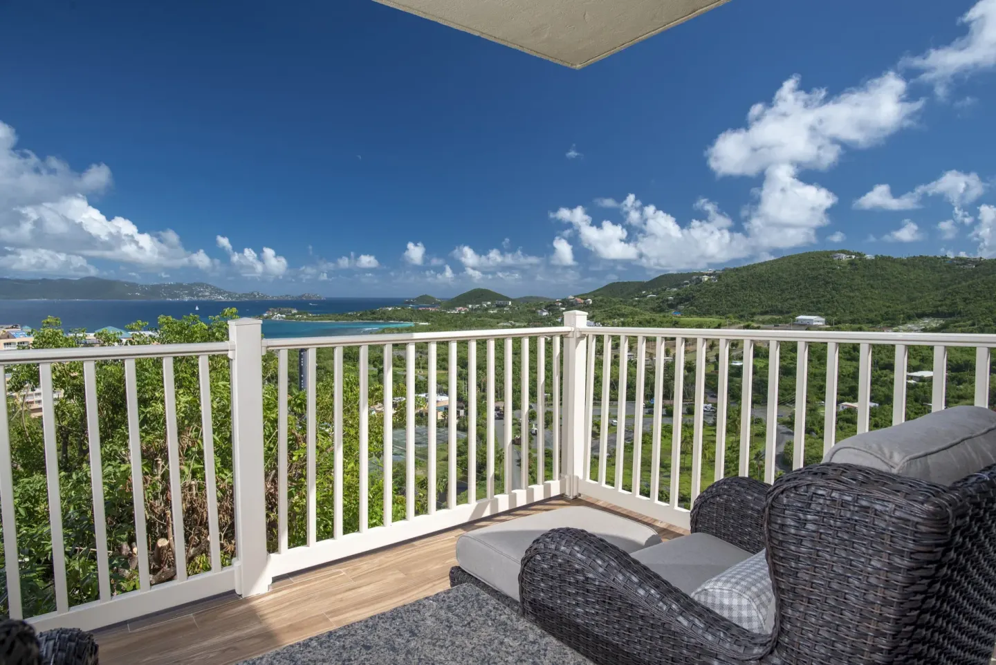 Furnished condo balcony with bay and hillside views at Point Pleasant Resort.