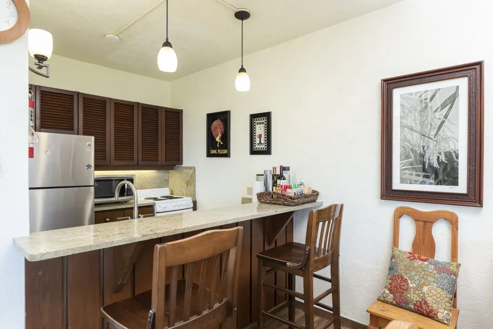 Condo kitchenette and bar seating with wall art at Point Pleasant Resort.