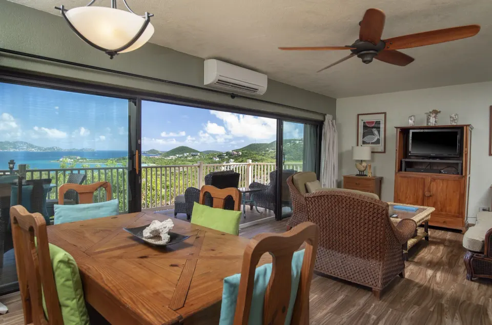 Condo living and dining area with balcony water view at Point Pleasant Resort.