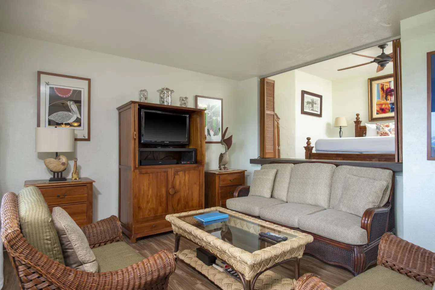 Condo living room with wicker seating and bedroom beyond at Point Pleasant Resort.