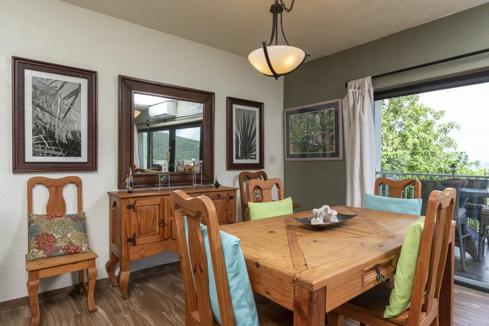 One-bedroom condo dining area with wood table and balcony doors at Point Pleasant Resort.