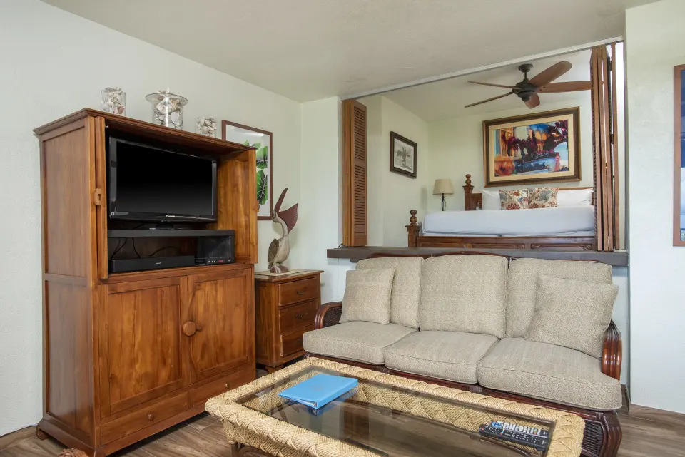 One-bedroom condo lounge with media cabinet and raised bed at Point Pleasant Resort.