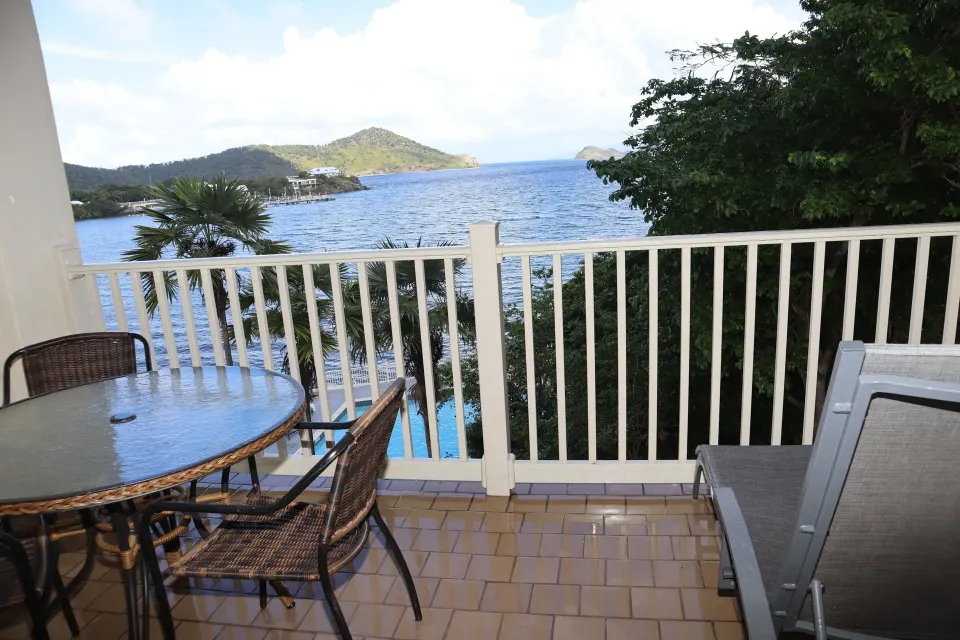 Studio balcony with dining table, lounge chair, and bay view at Point Pleasant Resort.
