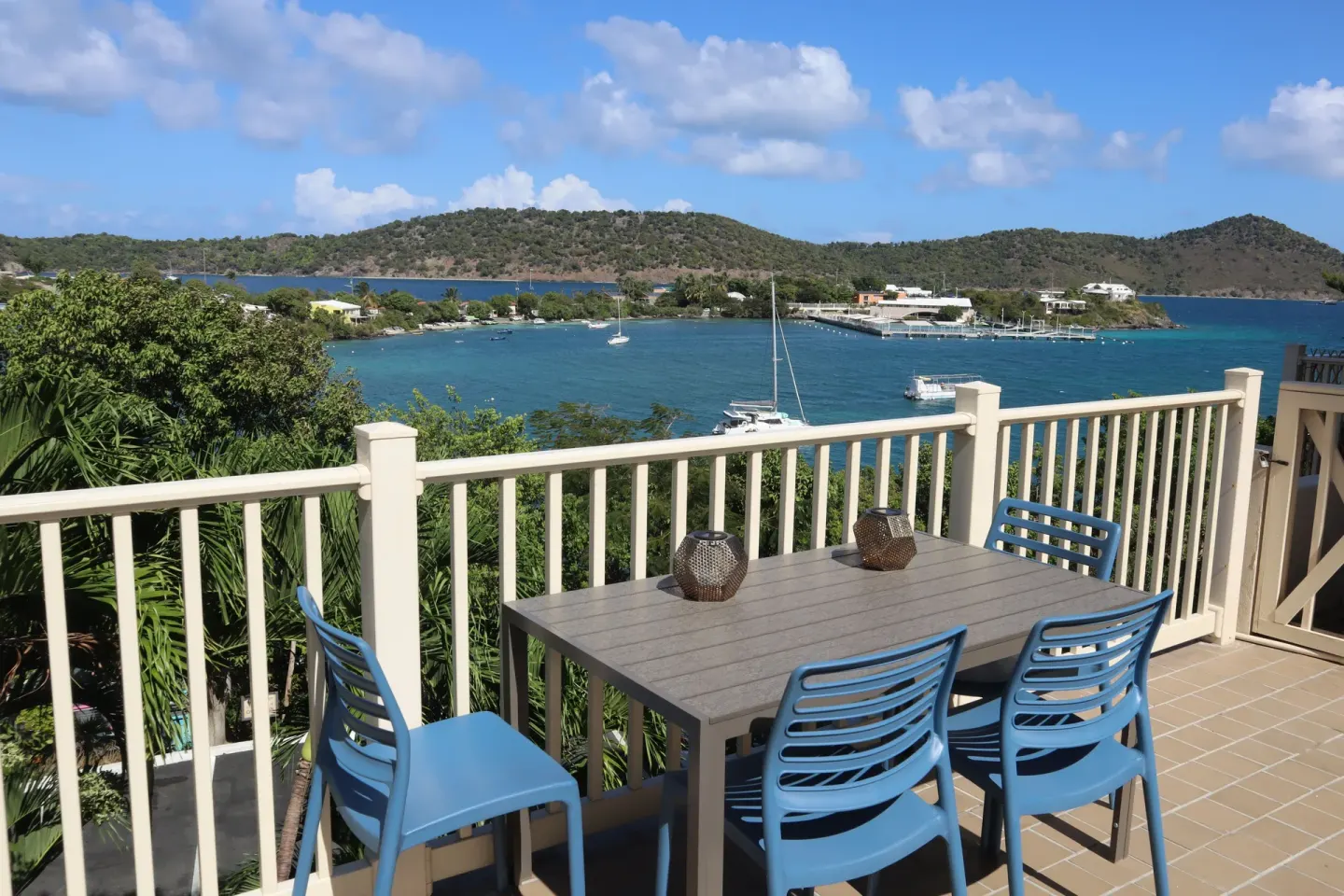 Studio balcony dining table with blue chairs and harbor view at Point Pleasant Resort.