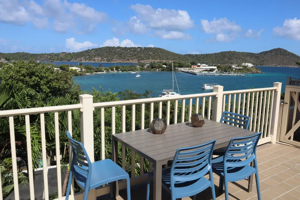 Studio balcony dining table with blue chairs and harbor view at Point Pleasant Resort.