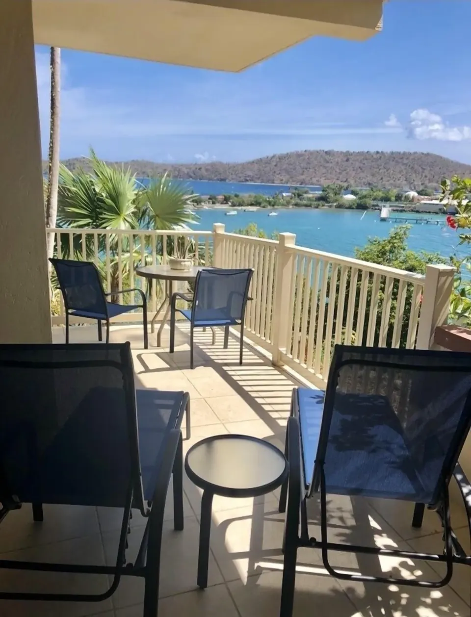 Studio balcony at Point Pleasant Resort with lounge chairs, table, and bay view.