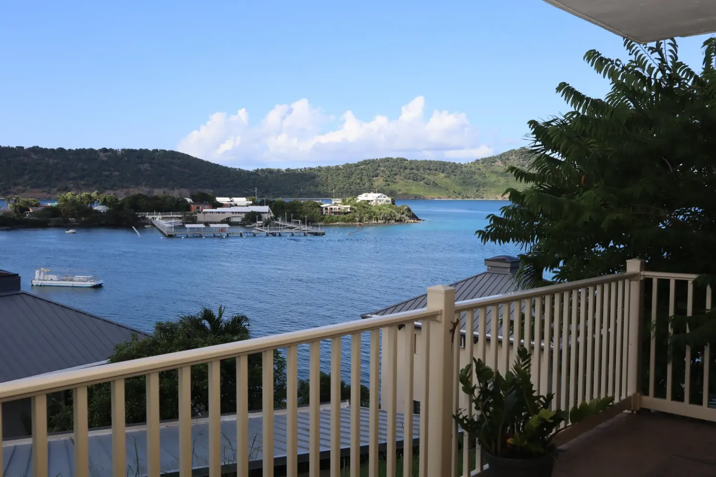 Studio balcony view of blue water, marina, and green hills at Point Pleasant Resort.