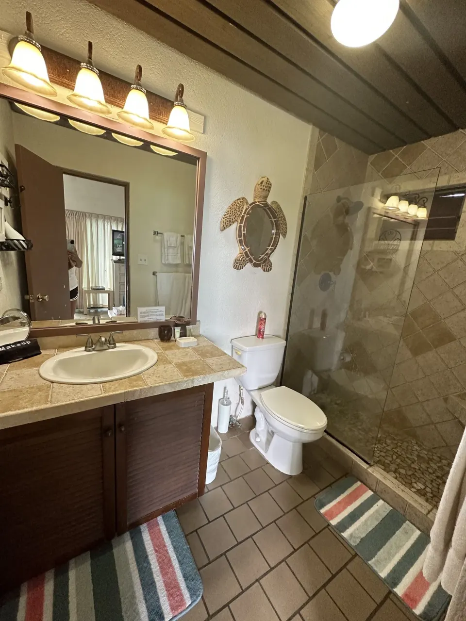 Studio bathroom with vanity, toilet, and glass shower at Point Pleasant Resort.
