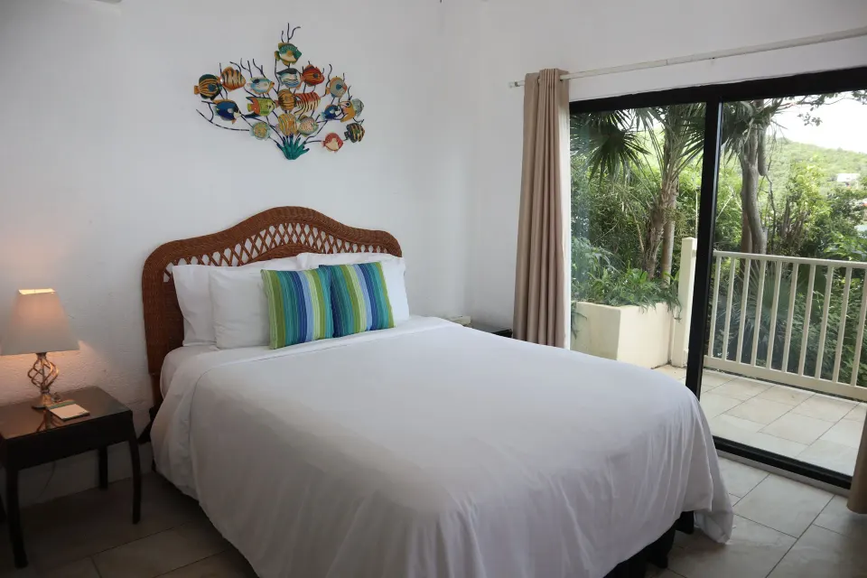 Studio bed beside sliding glass doors to a balcony at Point Pleasant Resort.