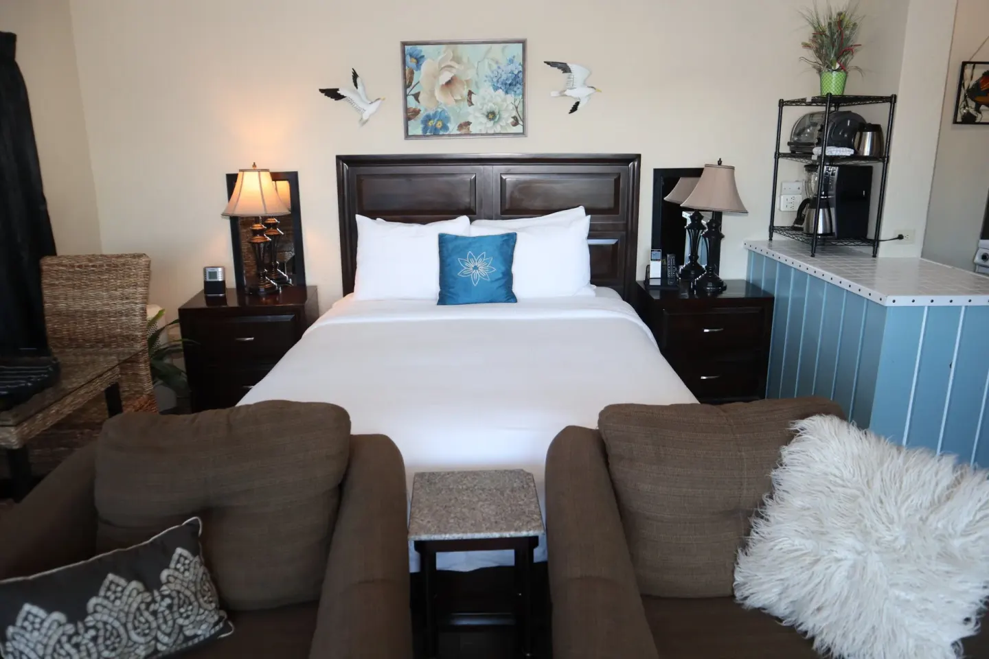 Studio room with bed, armchairs, and kitchenette counter at Point Pleasant Resort.