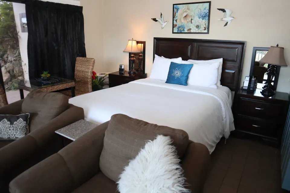Studio guest room with bed, seating, and side tables at Point Pleasant Resort.