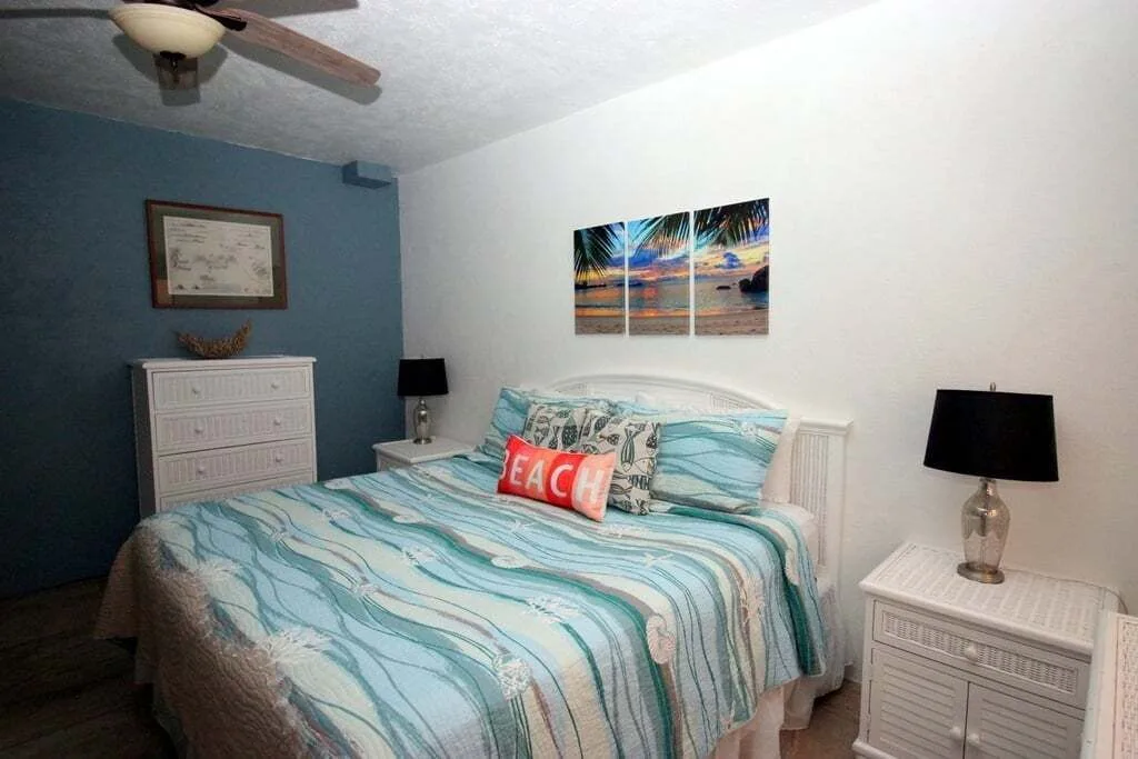 Studio bedroom with queen bed and beach decor at Point Pleasant Resort.