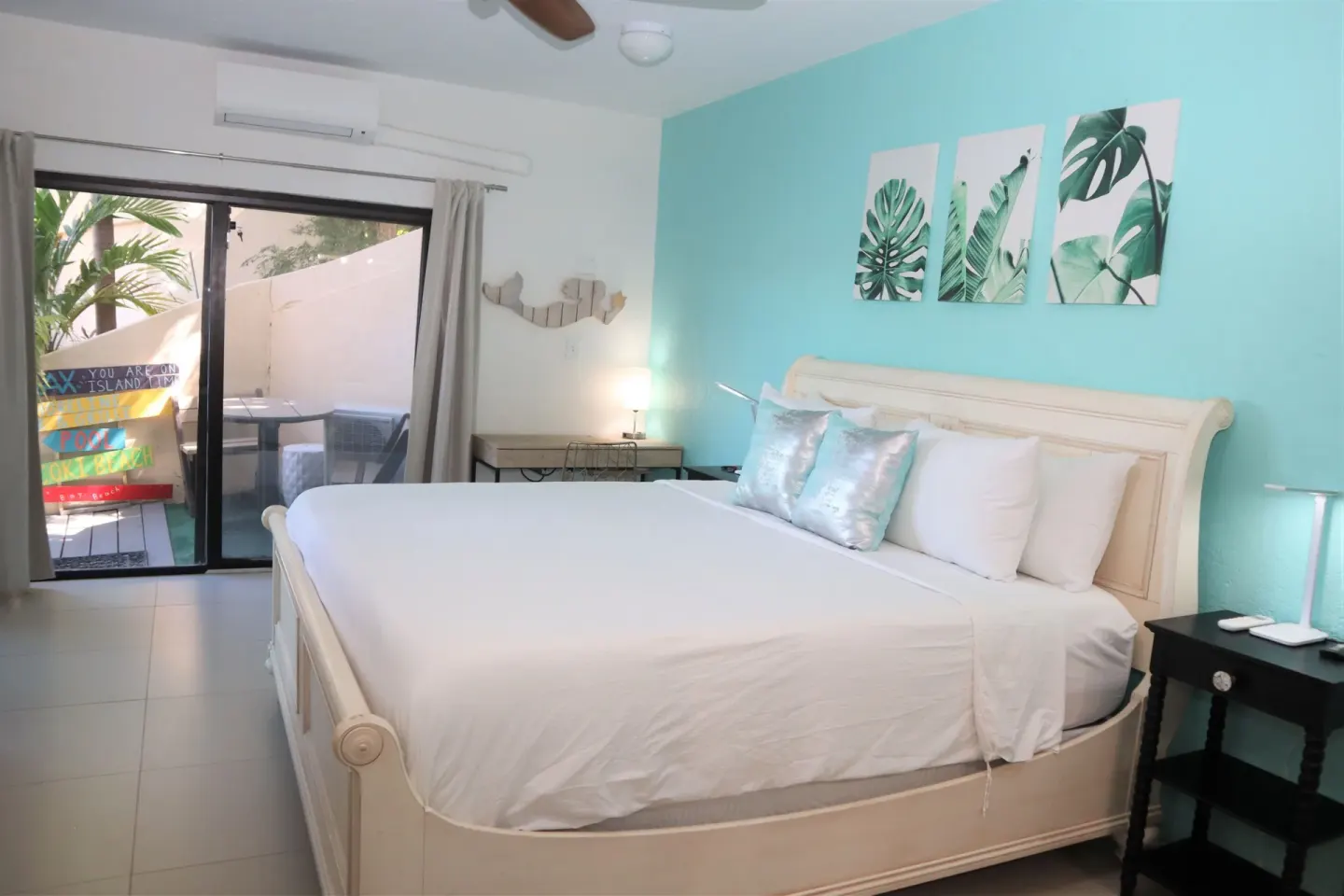 Studio bedroom with white bed and turquoise accent wall at Point Pleasant Resort.