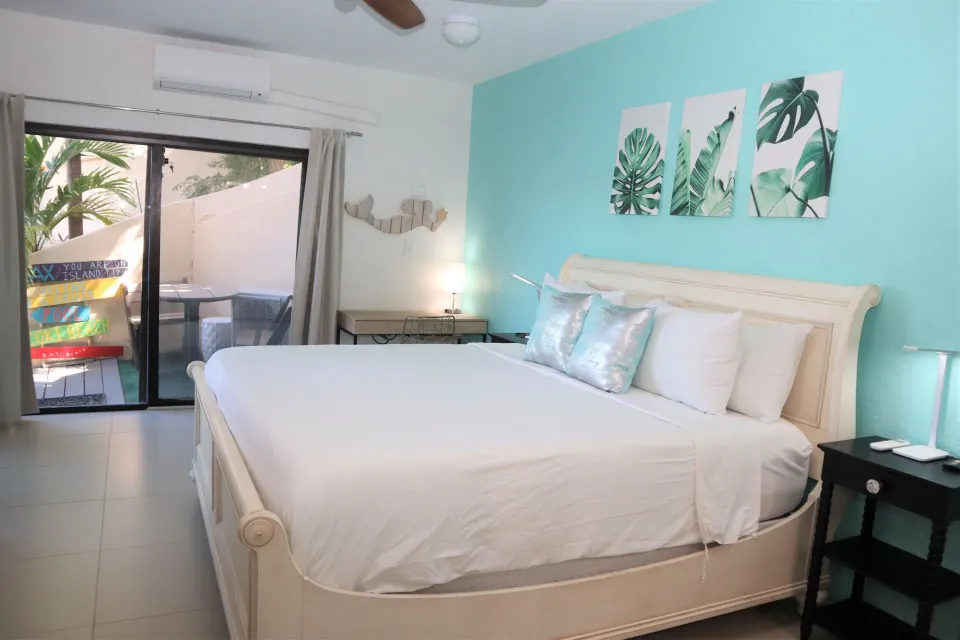 Studio bedroom with white bed and turquoise accent wall at Point Pleasant Resort.