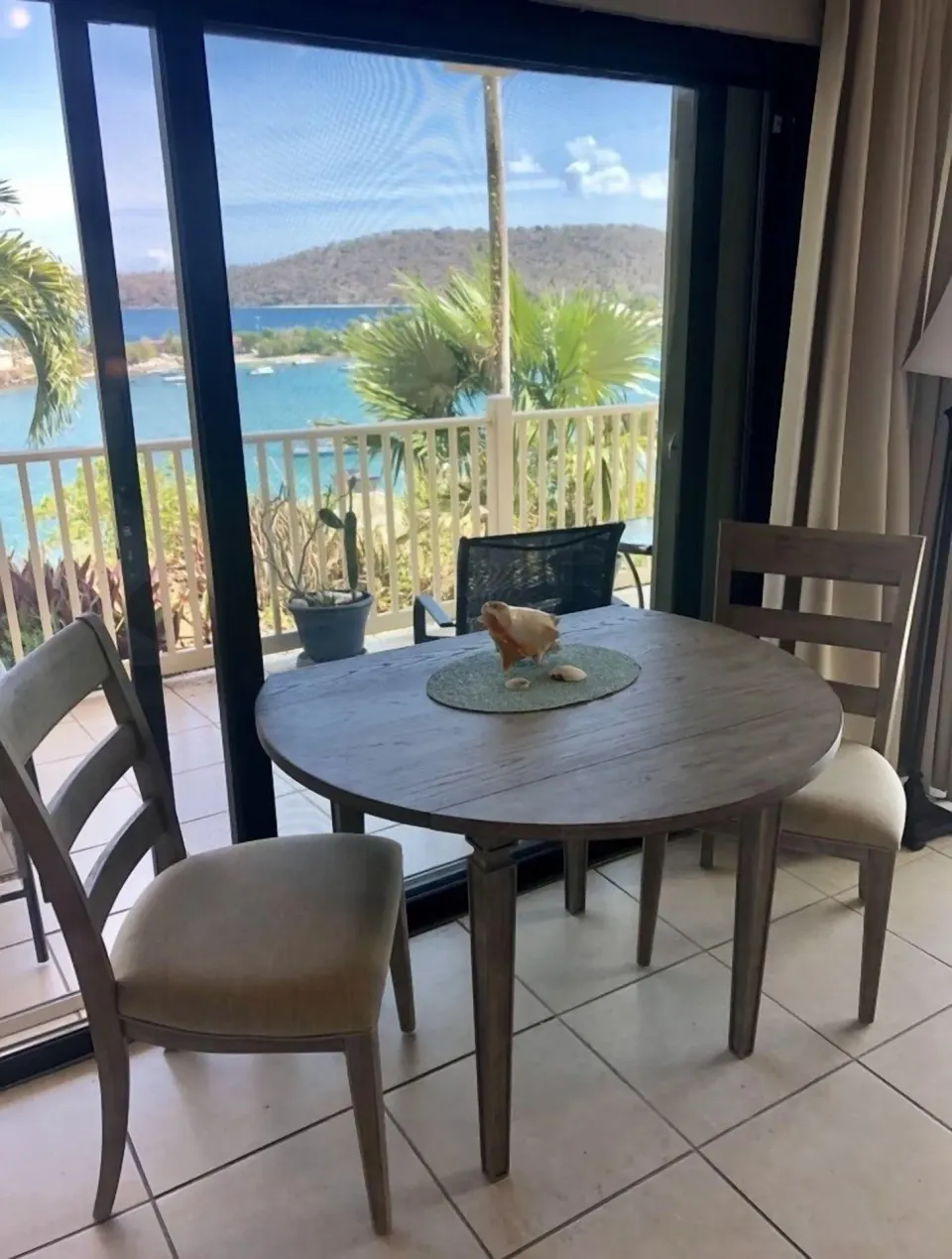 Studio dining area at Point Pleasant Resort beside sliding doors and a balcony water view.