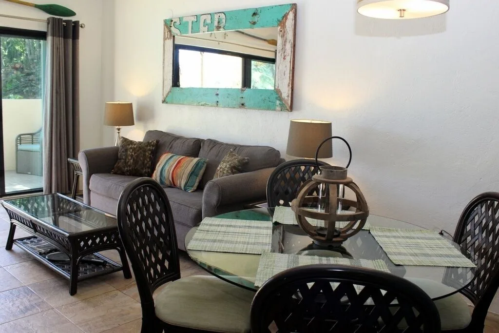 Studio dining table and sofa seating near balcony doors at Point Pleasant Resort.