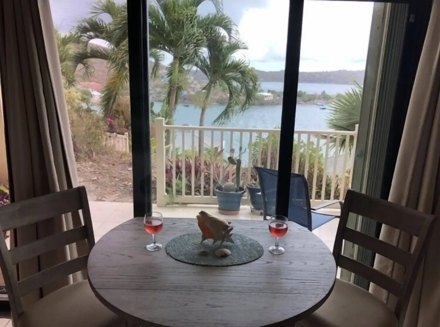 Studio dining table at Point Pleasant Resort with balcony doors, chairs, and water view.