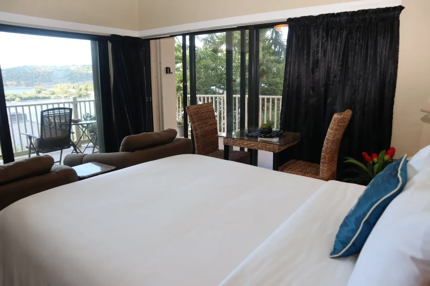 Studio king bed with sitting and dining areas by sliding doors at Point Pleasant Resort.