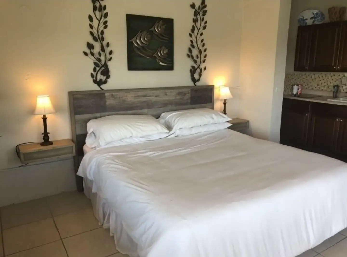 Studio at Point Pleasant Resort with bed, bedside lamps, and kitchenette visible.