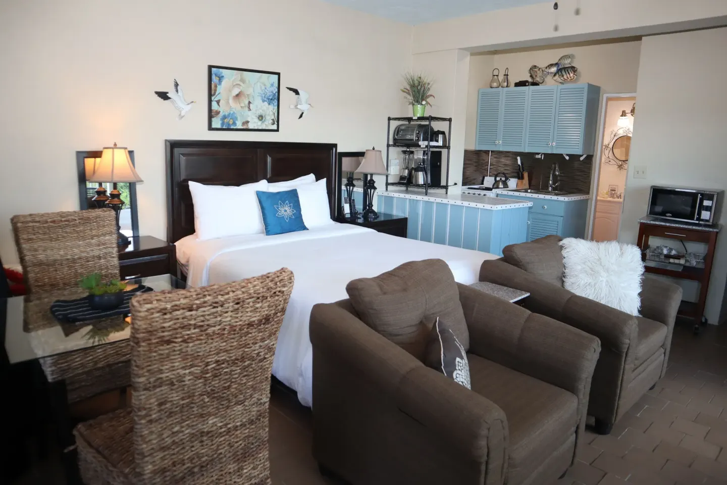 Studio king bed with lounge chairs, dining chairs, and kitchenette at Point Pleasant Resort.