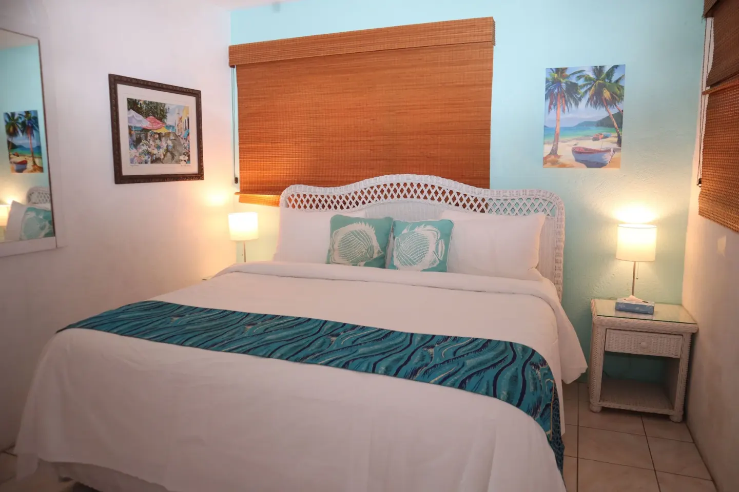 Studio king bed with white linens and turquoise accents at Point Pleasant Resort.