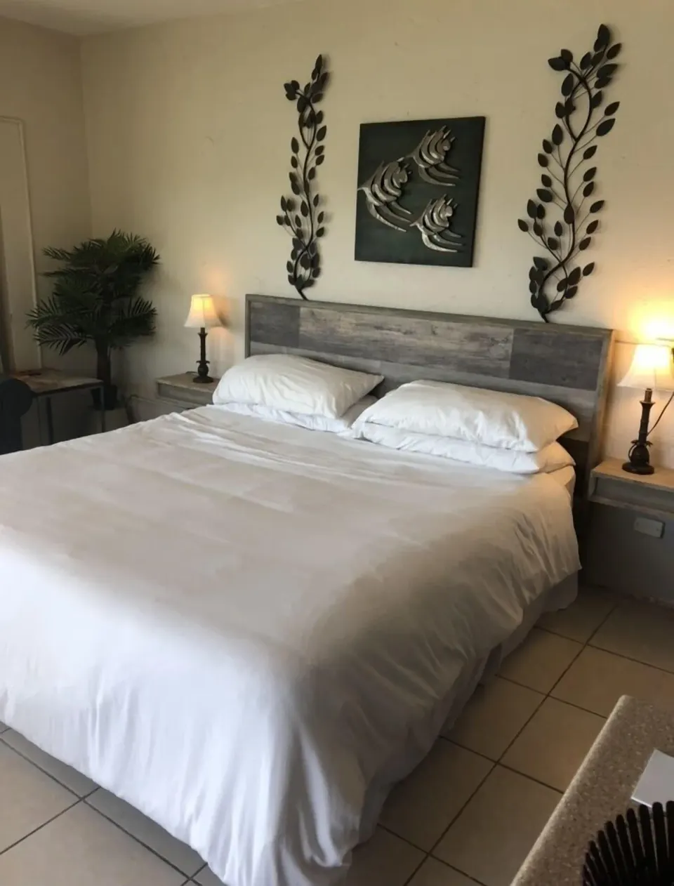 Studio bedroom at Point Pleasant Resort with white bedding, bedside lamps, and wall art.