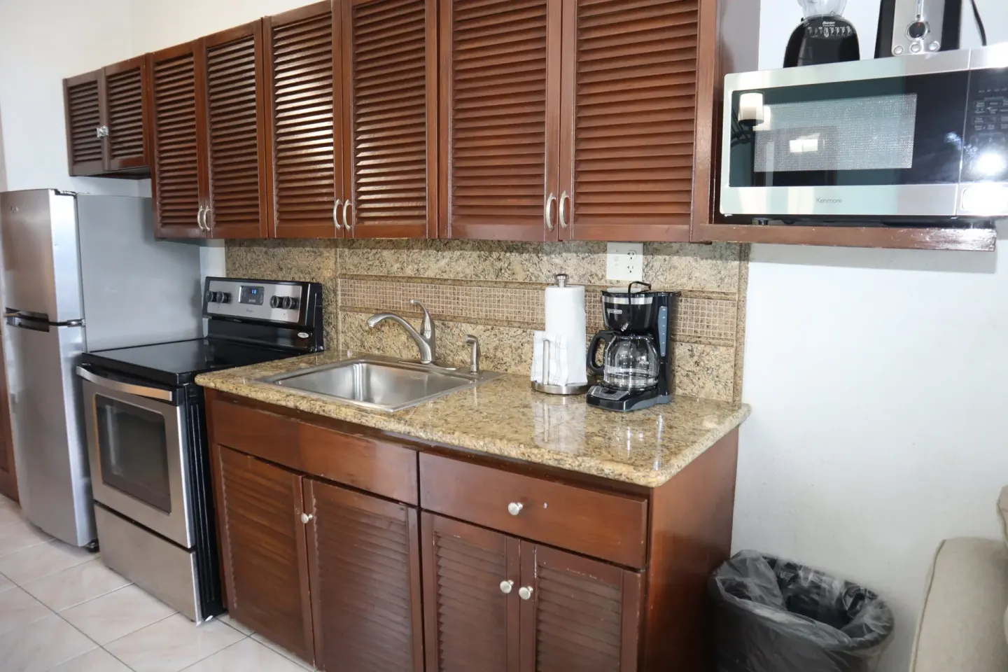 Studio kitchenette with range, refrigerator, sink, and microwave at Point Pleasant Resort.