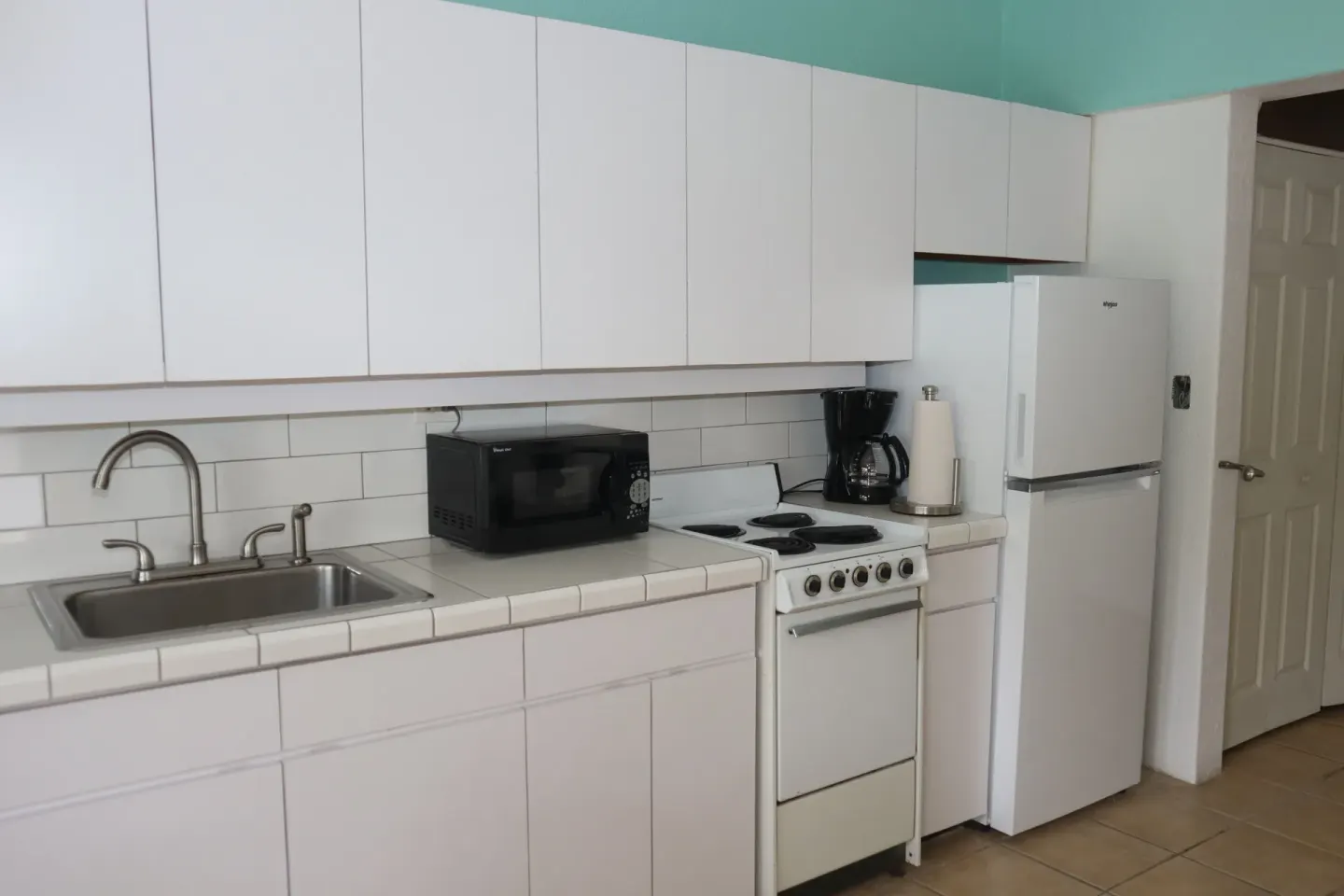 Studio kitchenette with sink, microwave, stove, coffee maker, and refrigerator at Point Pleasant Resort.