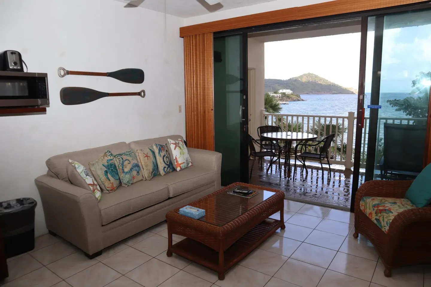 Studio living area with sofa, balcony, and water view at Point Pleasant Resort.
