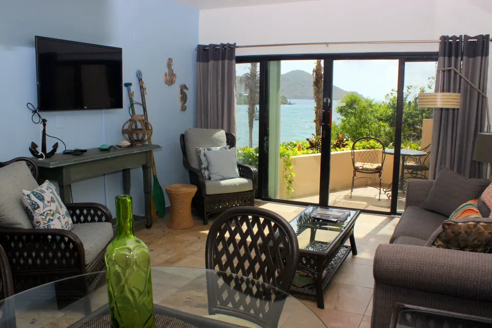Studio living area with seating and balcony water view at Point Pleasant Resort.