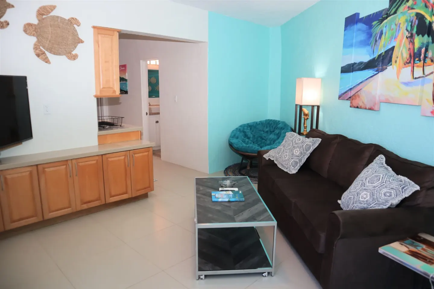 Studio living area with sofa, coffee table, and turquoise walls at Point Pleasant Resort.