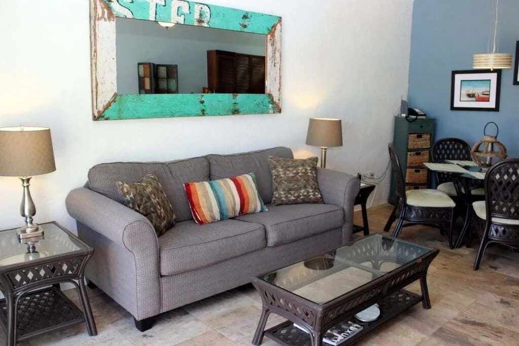 Studio living room with gray sofa and dining table at Point Pleasant Resort.