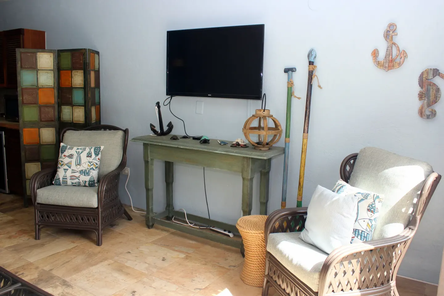 Studio lounge corner with TV console and wicker chairs at Point Pleasant Resort.