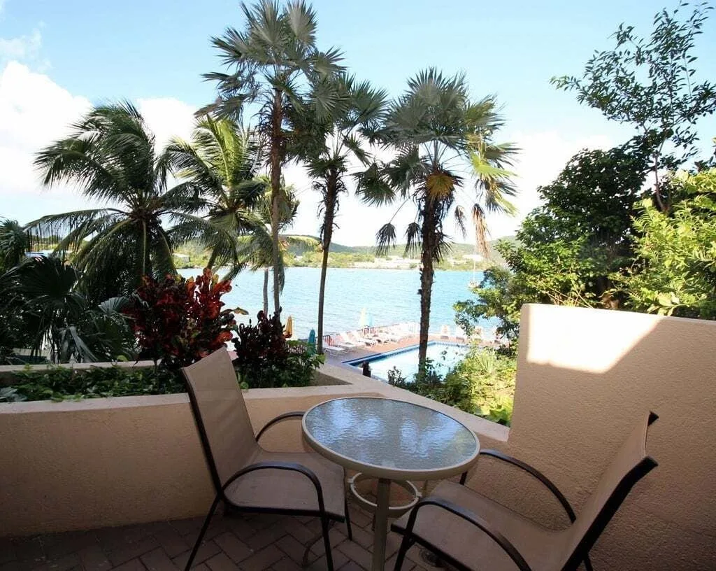 Studio patio seating with bay and pool view at Point Pleasant Resort.