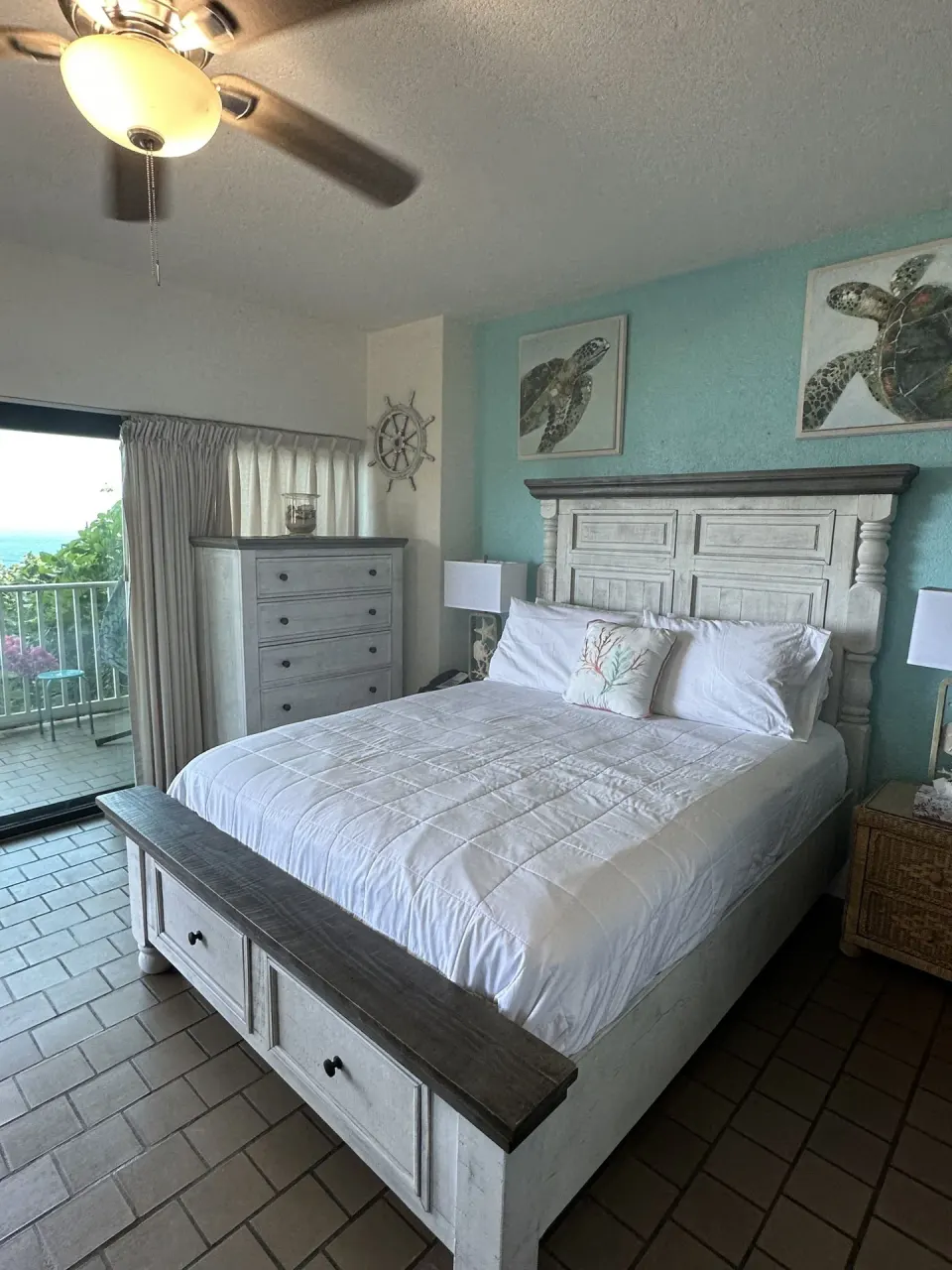 Studio bedroom with a bed, turtle art, and balcony doors at Point Pleasant Resort.