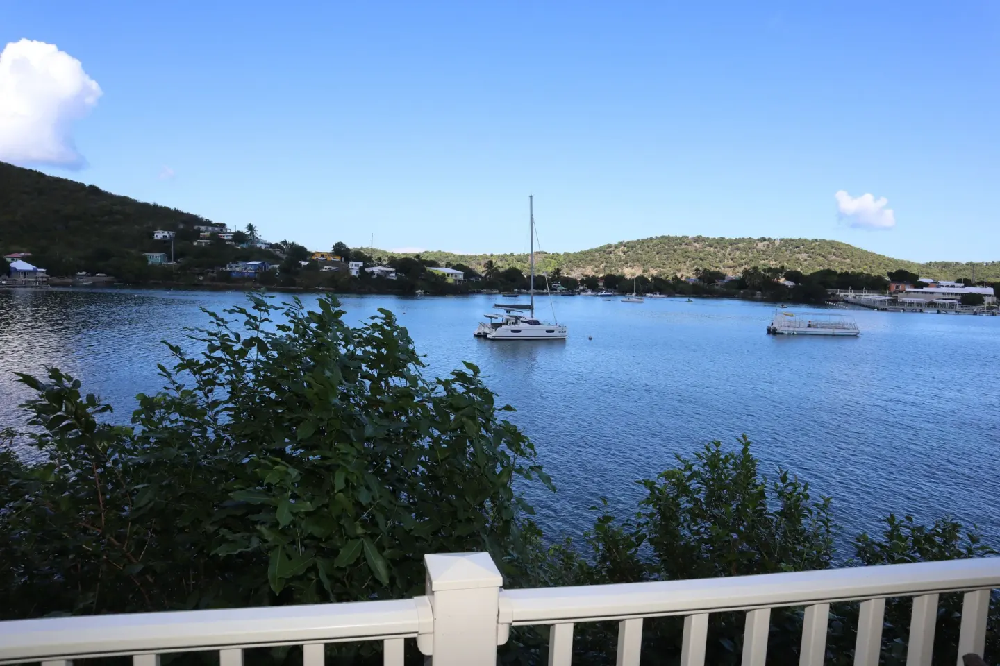 Balcony water view with boats, railing, and green hills at Point Pleasant Resort.