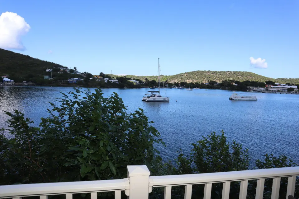 Balcony water view with boats, railing, and green hills at Point Pleasant Resort.