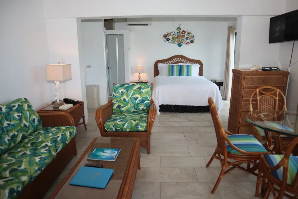 Studio room with bed, seating, dining table, and dresser at Point Pleasant Resort.