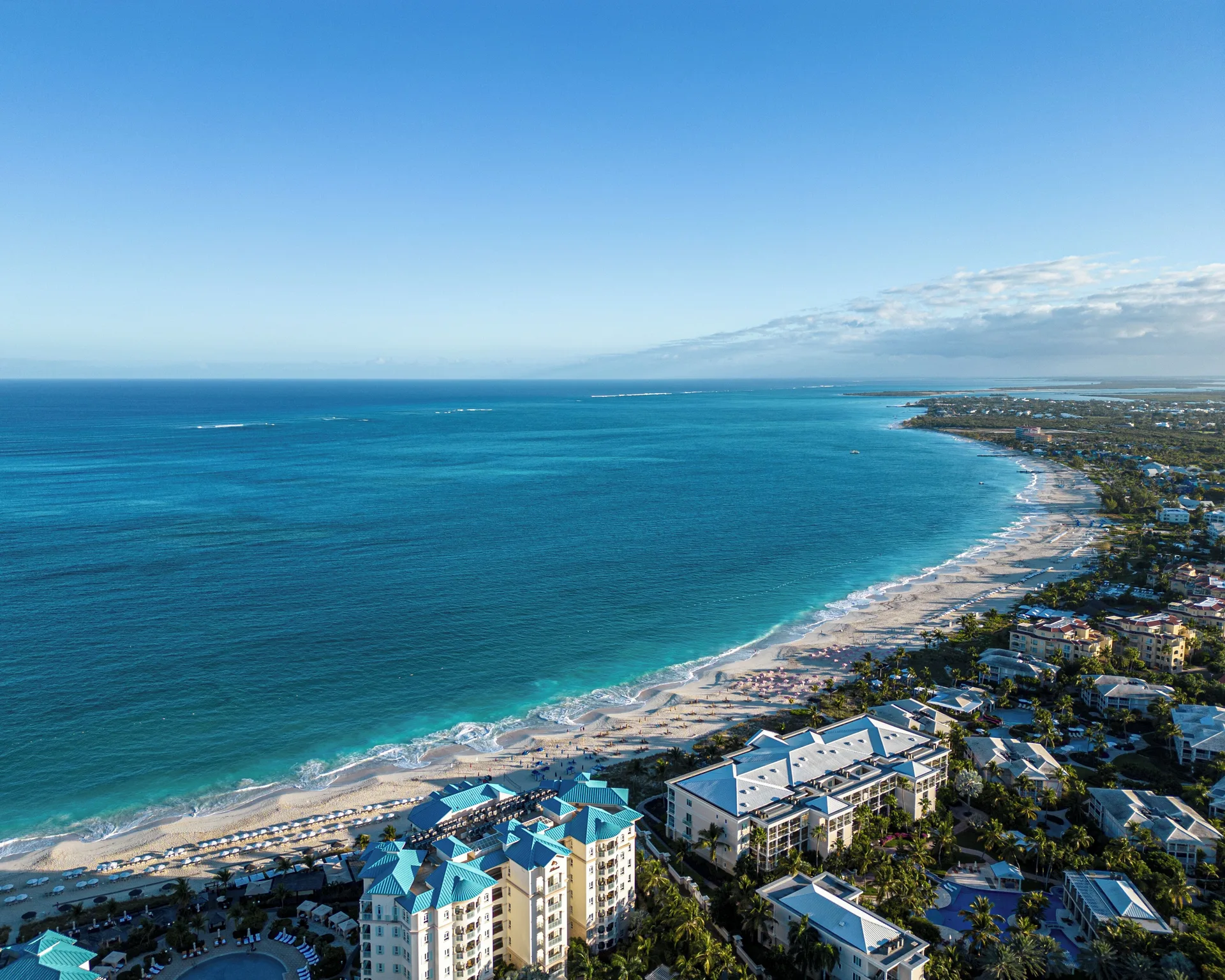 Aerial view of turquoise ocean and beachfront near Ports of Call Resort.