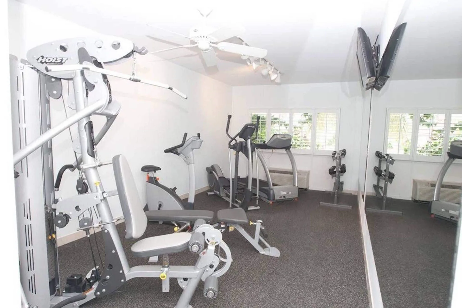 Fitness room with exercise machines and mirrored wall at Ports of Call Resort.