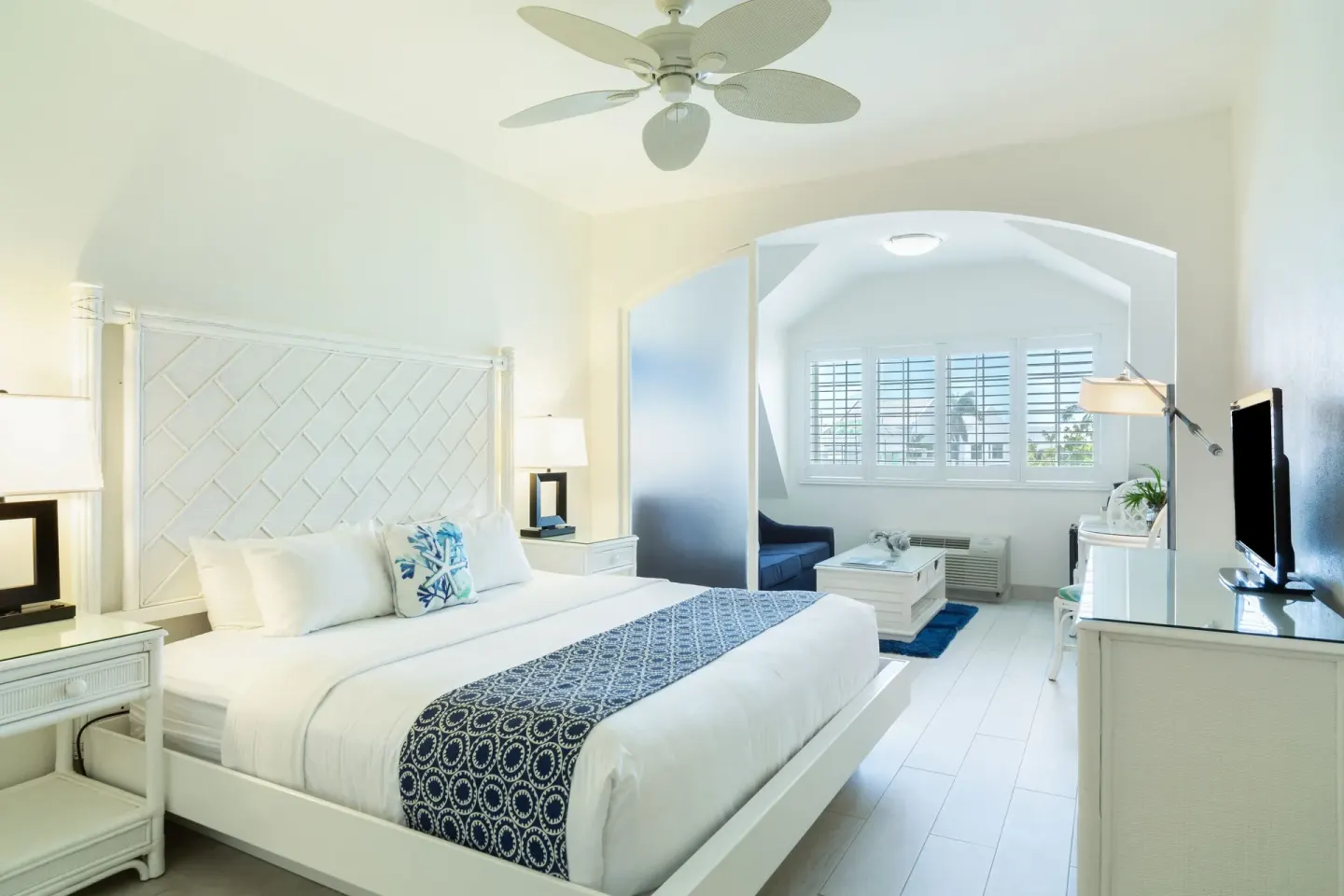 King bed with sitting area beyond in a guest room at Ports of Call Resort.