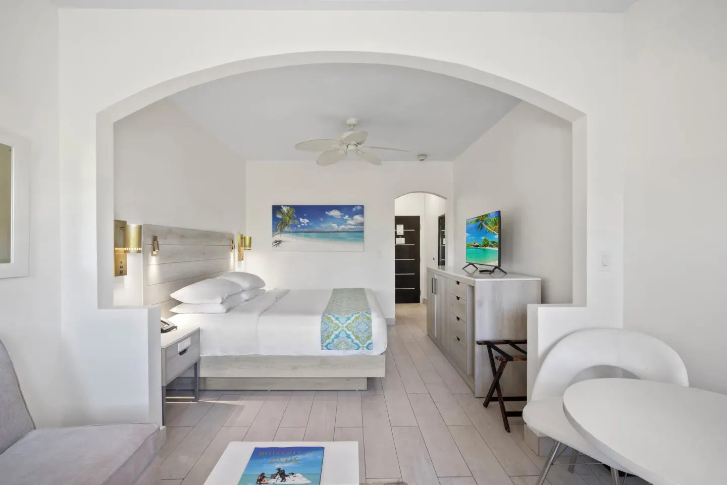 Guest room with king bed, TV, dresser, and sitting area at Ports of Call Resort.
