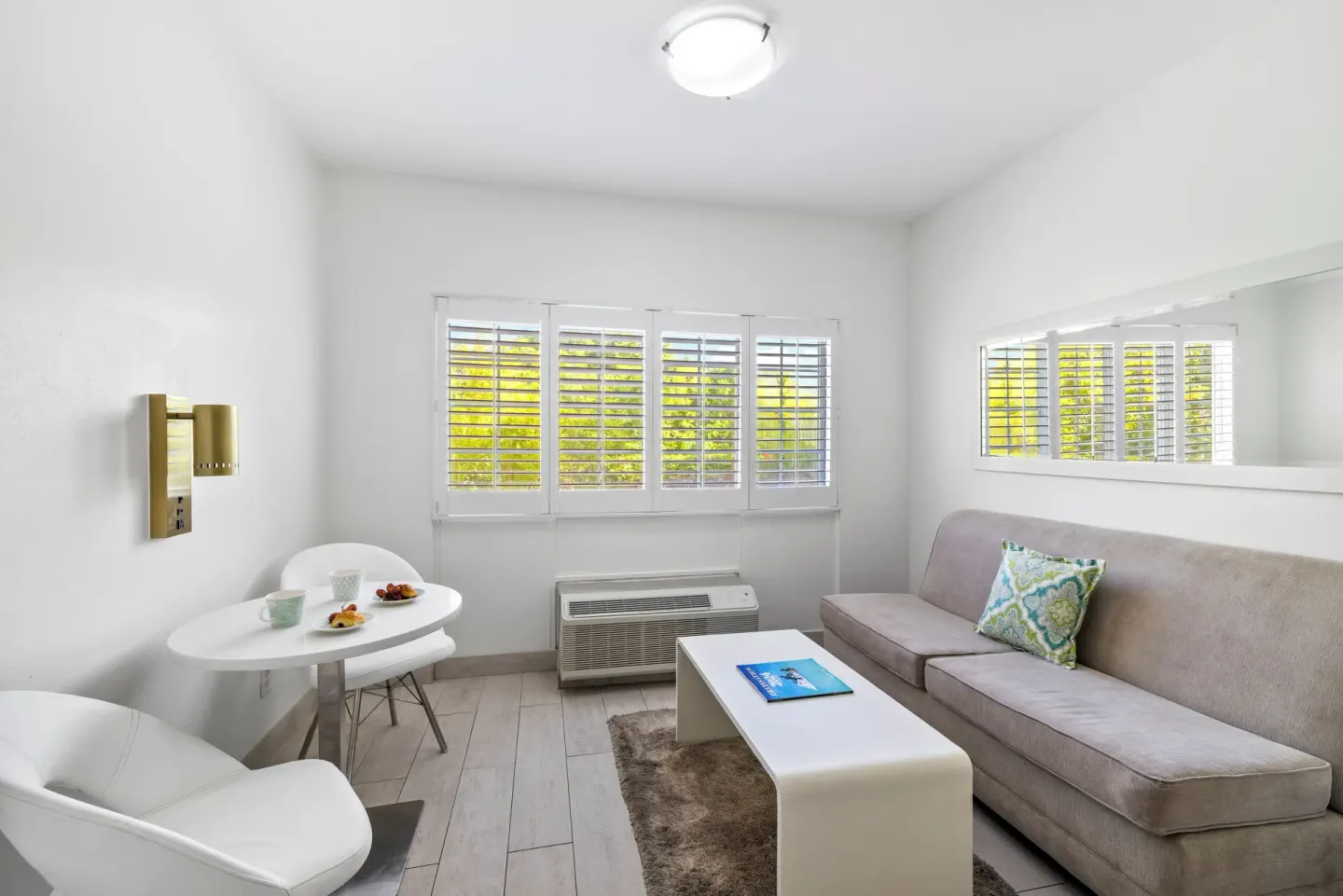 Sitting area with sofa and table in a guest room at Ports of Call Resort.