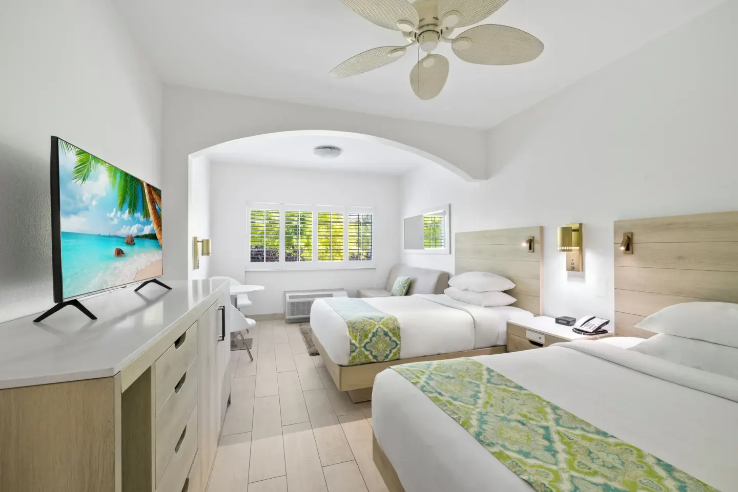 Two beds, dresser, and window alcove in a guest room at Ports of Call Resort.