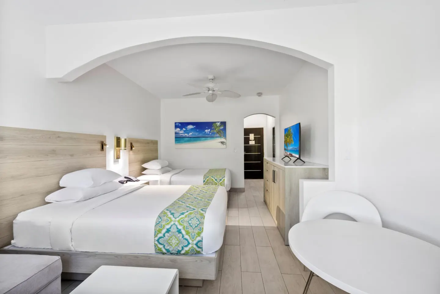 Two beds and a round table in a modern guest room at Ports of Call Resort.